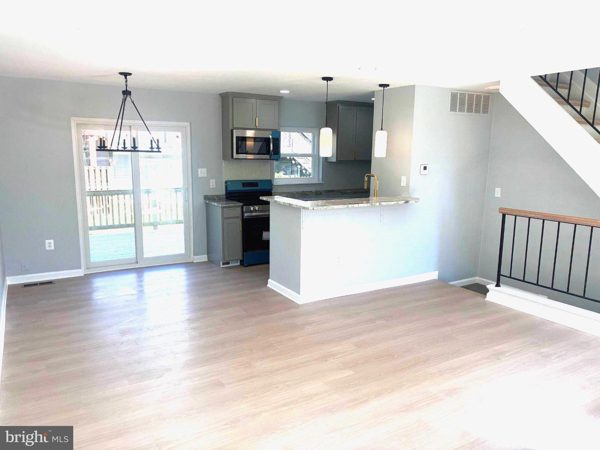 Open main level: living area through to the kitchen, new laminate floors
