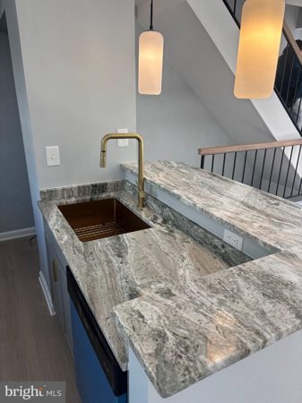 Gold-accent sink, natural-stone counters and island